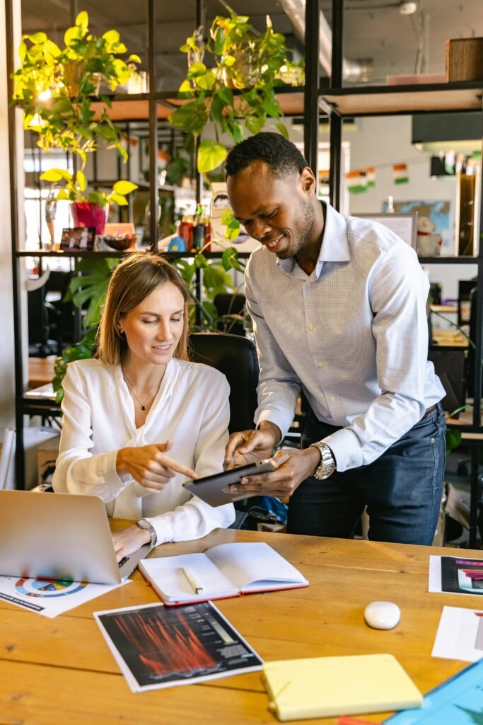 A diverse team collaborating in an office, using digital devices for productivity.